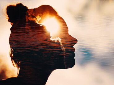 Sun peeks out from behind the clouds in woman's head.